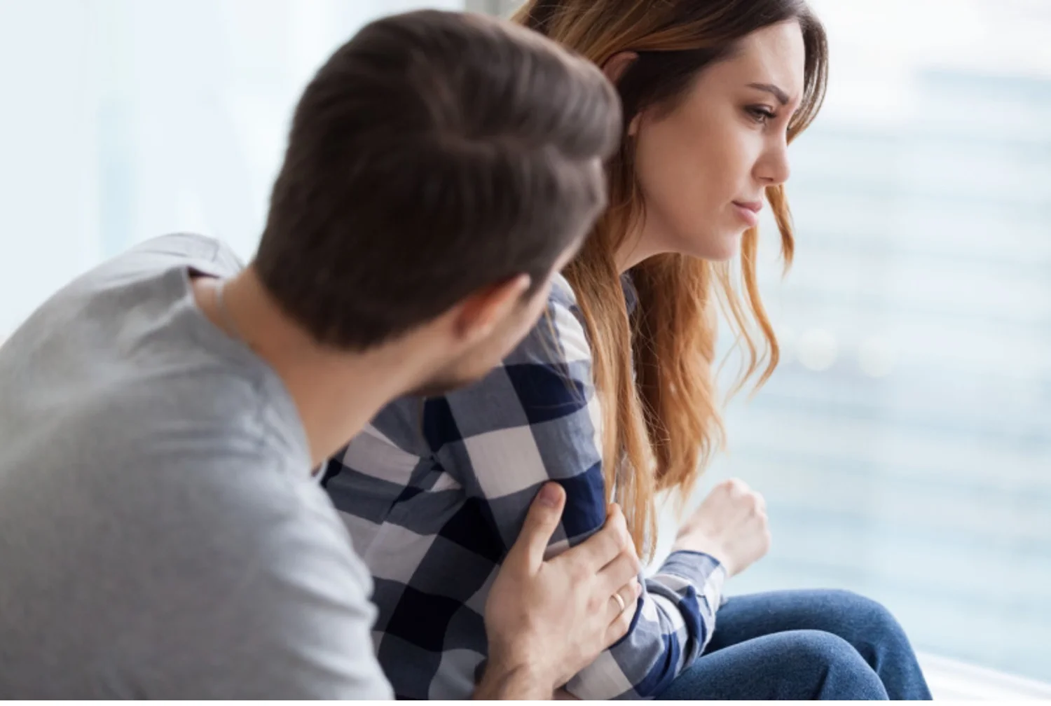 Concerned man comforts anxious woman