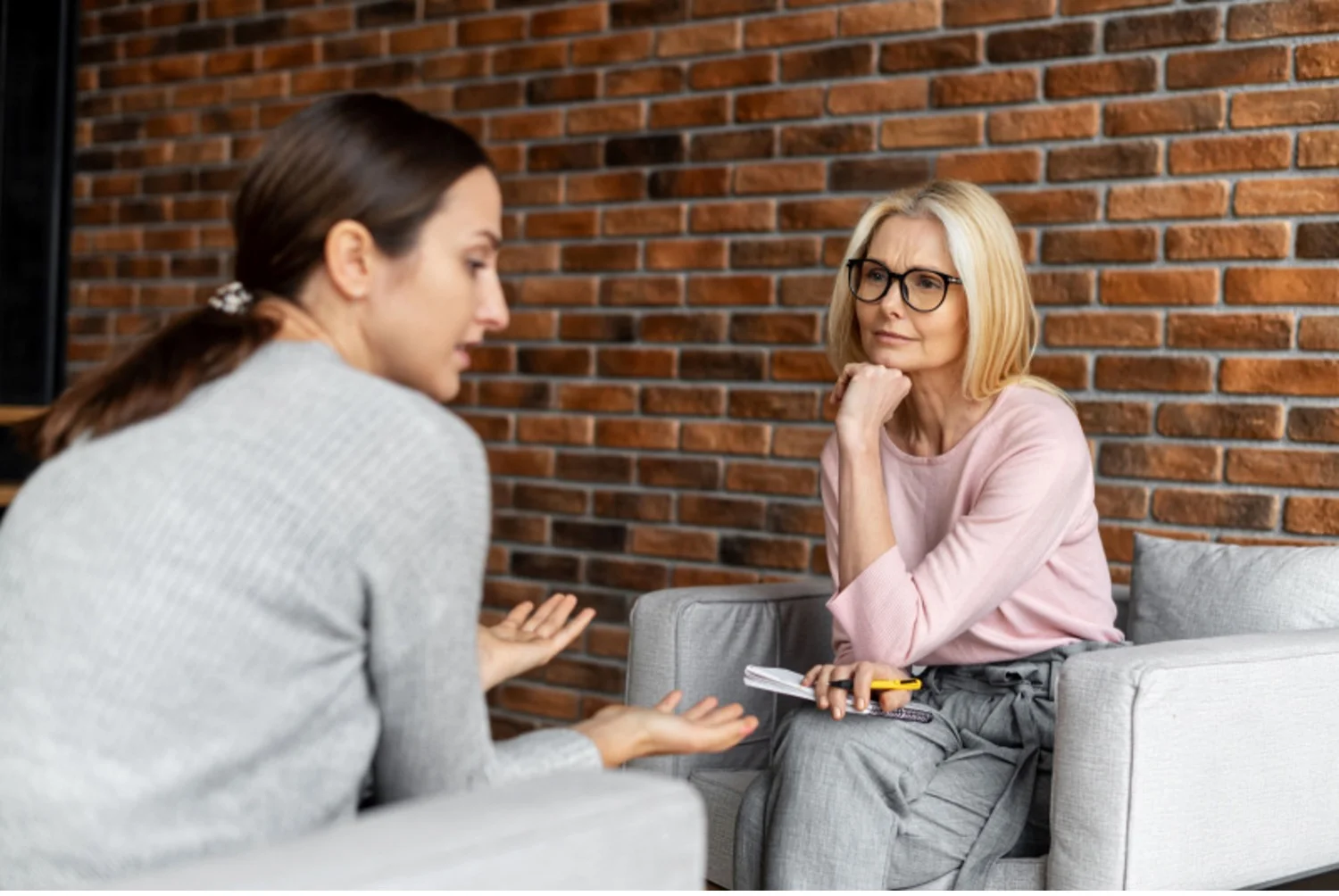 Therapist listens to young woman during treatment session