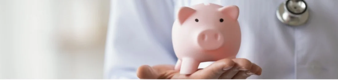 Doctor holds piggy bank in their hand