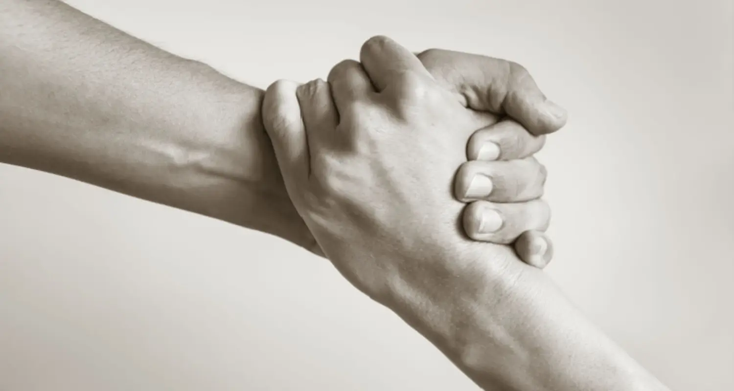 Black and white image of two hands clasped together