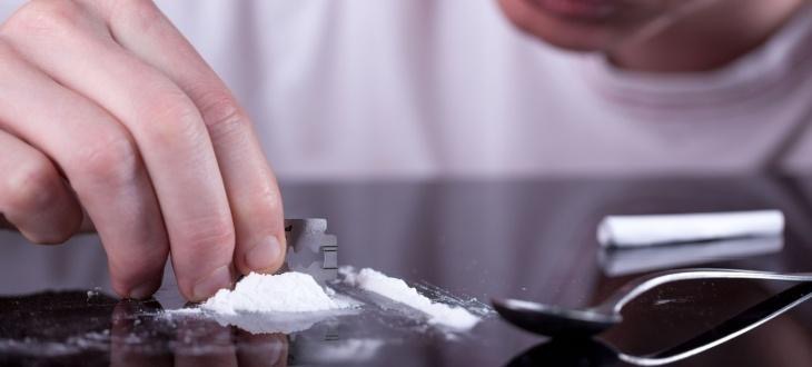 Person chops cocaine with razor blade next