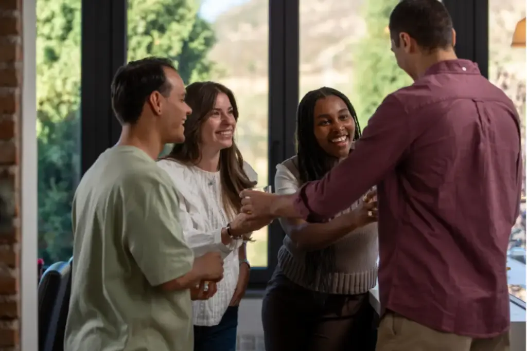 Group of people smiling and connecting in a warm, comfortable setting at a luxury addiction treatment center in Los Angeles, California, highlighting supportive community and holistic recovery.