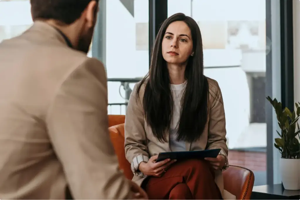 Addiction treatment professional meeting privately with a client in a confidential therapy session.